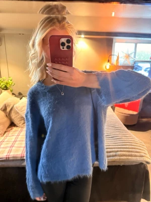 Mohair liknande stickad tröja - Mysig blå stickad tröja med fluffig yta och rund hals. 