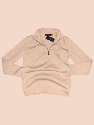 Beige half zip tröja från Polo Ralph Lauren - Snygg beige långärmad tröja från Polo Ralph Lauren med klassisk krage och half zip-dragkedja. Tröjan har broderad logga på bröstet och är gjord i mjuk bomull. Perfekt för dig som gillar stilrena och bekväma plagg med premiumkänsla.