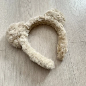 Beige fluffigt diadem med öron - Supersött diadem i beige fuskpäls med mjuka, runda öron.