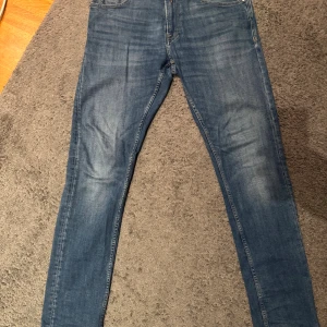 blå Replay jeans slim tapered fit - Säljer ett par blå jeans från Replay, storlek 31. Jeansen har en slim tapered fit med klassisk femficksdesign och snygga detaljer vid fickorna. Materialet är jeans och färgen är en mellanblå tvätt som passar till det mesta. En väldigt clean look helt enkelt 🤩