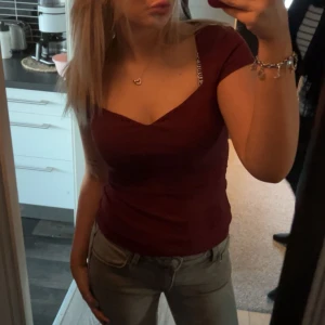 Vinröd v-ringad topp - Säljer en vinröd topp med v-ringad hals och korta ärmar. Snygg, figurnära passform som framhäver siluetten. Perfekt att matcha med jeans eller kjol för en trendig look. Materialet känns mjukt och stretchigt mot huden från Zalando i storlek S i superbra skick💕
