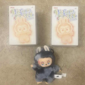 Pop Mart Big Into Energy Plush Figure - Söt samlarfigur från Pop Mart Big Into Energy-serien, komplett med originalförpackning. Figuren är i nyskick och har ett mjukt, fluffigt yttre samt färgglada ögon. Perfekt för samlare eller som present. Inga synliga defekter eller slitage.