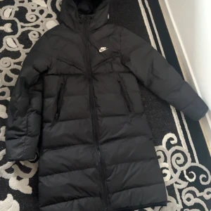 Nike Lång Jacka (Sällsynt) - Säljer denna riktigt fräscha och varma Nike jacka (lång) som inte säljs längre, en jacka som kommer hålla dig varm hela vintern och stilig. Inga skador eller några konstigheter!!! Pris kan diskuteras!!!!!