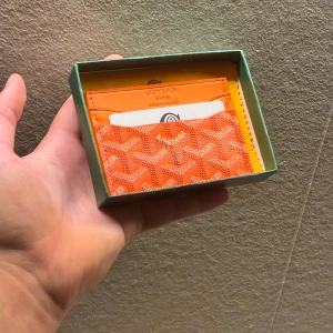 Orange korthållare  - Snygg orange korthållare med ikoniskt mönster och flera kortfack. Tillverkad i skinn material och  Perfekt för dig som vill ha något både stilrent och unikt i fickan.