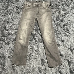 Grå jeans från Replay - Snygga grå jeans från Replay med klassisk femficksdesign och raka ben. Jeansen har en cool tvättad look och tydliga Replay-detaljer som patch bak i midjan. 