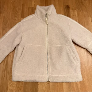 teddyjacka - Supermjuk och fluffig vit teddyjacka med hög krage och hel dragkedja framtill. Perfekt för kyliga dagar. Den har tyvärr blivit lite missfärgad (mörkblå) längst ner på insidan pga ett par jeans jag hade på mig en gång, men inget alls som synd när den är på. Annars är den som ny. Från new yorker säljs inte mer 🥰