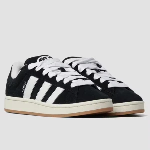 Adidas Campus svarta sneakers mocka - Klassiska Adidas Campus 00 sneakers i svart mocka med vita detaljer och de ikoniska tre ränderna på sidorna. Skorna har vit sula, breda vita skosnören och Adidas-logga på häl och plös. Nypris: 1500kr 
