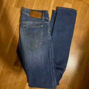 Tiger of Sweden slim jeans 29/32 - Snygga blå jeans från Tiger of Sweden med klassisk femficksdesign och smal passform. Jeansen har mellanblå tvätt, diskreta slitningar och läderpatch bak i midjan. 