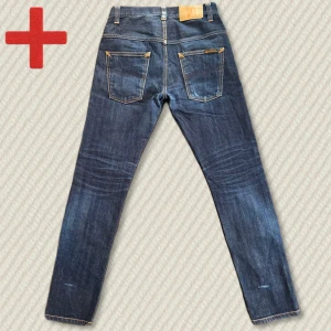 Nudie Jeans Thin Finn Selvedge - Grymma Nudie Thin Finn Selvedge med massor av fadepotential kvar! Inga skador och i riktigt bra skick. Storlek 28/30. Mått: Midja – 37,5 cm, Innersöm – 73 cm, Yttersöm – 98 cm, Lår – 23,5 cm, Benöppning – 15 cm. Skriv gärna vid frågor! 
