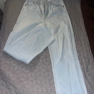 Ljusblå straight jeans från hm  - Säljer ett par ljusblå jeans från hm med klassisk  raka ben. Modellen är straight och har hög midja. Jeansen är tillverkade i jeansmaterial och har en enkel, clean look med ljus tvätt och metallknappar.
