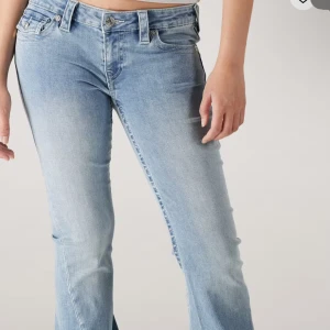 True Religion ljusblå bootcut jeans - Säljer ett par ljusblå jeans från True Religion, modell BECCA Mid Rise Bootcut. Jeansen har en väldigt skön passform, dock är de ihop sydda bak under en ficka men inget som man tänker på när man har på sig jeansen. På sista bilden ser du hur de är ihopsydda!💞
