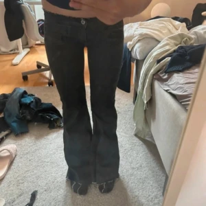 Svarta bootcut jeans med slits - Säljer ett par svarta jeans med bootcut. Materialet är jeans och färgen är mörk svart,  köpta på vinted som tyvärr va för små för mig, därav lånade bilder. De passar nog XS kanske S men de sitter tajtare vid låren då tidigare ägaren har sytt om de  fråga om innerbenslängden och midjemått!