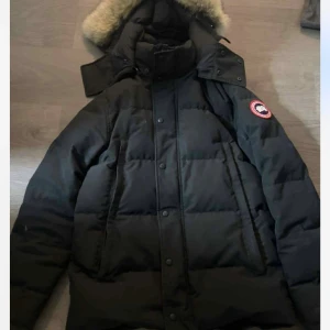 Svart jacka från Canada goose - Säljer en svart jacka från Canada Goose med klassisk patch på ärmen och luva med päls 