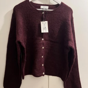 Vinröd kofta från Gina Tricot - Mysig vinröd kofta från Gina Tricot med knappar! Kan användas som en tröja eller något man har över klänningen osv.. helt ny och använd endast provat! 