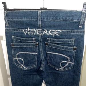 Vintage jeans  - Mörkblå jeans med kontrastsömmar och broderad “VINTAGE”-text bak i storlek 152