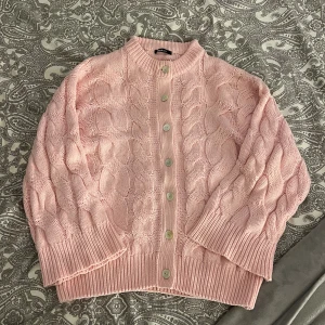 Rosa kofta  - Rosa kabelstickad kofta från Gina Tricot. Toppenskick! Kolla gärna in mina andra annonser och lägg gärna bud på bundle. Fri frakt även på bundle!