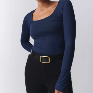 Marinblå topp Gina - Säljer en marinblå långärmad topp från Gina i storlek xs, den har även en liten slits på båda armarna! Den rosa bilden är endast en exempel.