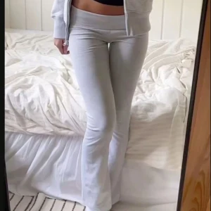 Ljusgrå bootcut mjukisbyxor - Supersköna ljusgrå mjukisbyxor med låg midja och bootcut-ben. Perfekta för en chill och avslappnad look. Mjukt material som sitter bekvämt och följer kroppen.