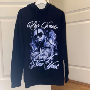 Pop Smoke hoodie - Svart oversized hoodie med Pop Smoke tryck i vitt och blått på framsidan. Den har inte kommit till användning för den passa inte mig 