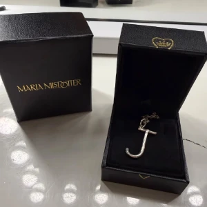 Maria Nilsdotter halsband J - Säljer mitt silvriga Maria Nilsdotter halsband i bokstaven J. Nypris = 1995kr, samt är den i längden 45cm. Har använt den en del men inte så att det syns, finns alltså inga defekter💕🌺
