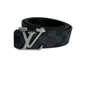 Louis Vuitton svart rutigt bälte - Svart bälte från Louis Vuitton med klassiskt rutigt Damier-mönster och stor LV-logga i silverfärgad metall som spänne. Tillverkat i exklusivt skinn med präglad logotyp på insidan. Perfekt accessoar för att lyfta din outfit.