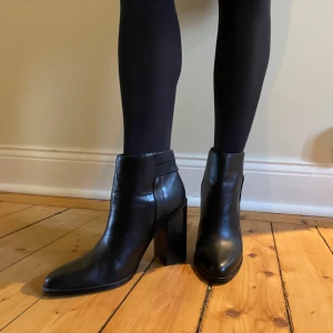 Svarta stövletter med klack i skinn - Jättefina svarta klackar i skinn från Other stories. Superenkla att matcha med olika outfits. Använda men i väldigt fint skick.💝