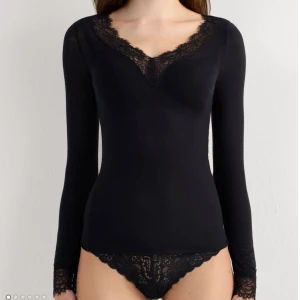 Svart intimissimi tröja med spets - Svart långärmad topp från Intimissimi med v-ringning och fina spetsdetaljer vid halsringning och ärmslut. Den har bra kvalitet och jag har haft den i ett år men bara används ett fåtal gånger,därav säljer jag den💗