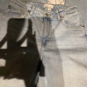 Ljusblå jeans från H&M, strl 40 - Säljer ett par ljusblå jeans från H&M i storlek 40. Klassisk femficksmodell med dragkedja och knapp framtill. Jeansen har raka ben och är tillverkade i bomullsdenim. Perfekta för en avslappnad och trendig look.