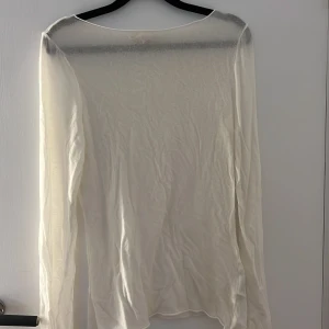 Vit långärmad topp från H&M - Säljer en tunn och lätt vit långärmad topp från H&M. Modellen är enkel med rund halsringning och har en något transparent känsla. Perfekt att styla lager på lager eller till ett par jeans. Supermjuk och skön mot huden.