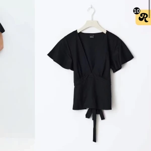 Svart omlottopp med knytband - Snygg svart omlottopp med v-ringning och korta, vida ärmar. Toppen har knytband i midjan som ger en fin passform och markerar midjan. Perfekt att styla med både jeans och kjol. Använd några gånger ❣️skriv om ni vill ha egna bilder❤️