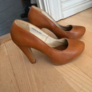 Bruna pumps med klack - Säljer ett par snygga bruna pumps från Dinsko perfekt för dig som vill ha en klassisk och stilren look. 