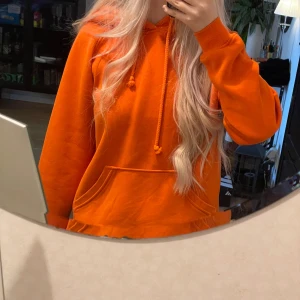 Orange hoodie från Bik Bok - Säljer en riktigt snygg orange hoodie från Bik Bok. Tröjan har huva med dragsko, stor magficka och långa ärmar. Perfekt för dig som gillar färg och vill sticka ut lite extra. Skön och mjuk, passar till chill dagar eller när du vill vara bekväm.💕