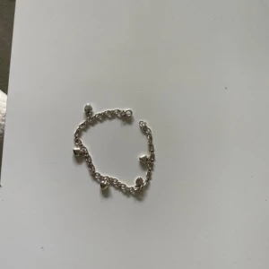 Silverfärgat armband med hjärtberlocker - Charmigt armband i silverfärg med flera små hjärtformade berlocker. Kedjan är tunn och smidig, perfekt för att ge en söt touch till din outfit. Passar dig som gillar enkla men fina detaljer.