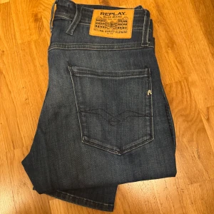 Replay Anbass jeans blå, stl 31/32 - Säljer ett par snygga Replay Anbass jeans i klassisk blå tvätt. Jeansen har raka ben, fem fickor och detaljerad bakficka med Replay-logga. Skön passform och stilren look, perfekta till vardagsoutfiten. Materialet är slitstarkt jeans i bomull. Storlek 31/32 köpt på Zalando för 1200kr jeansen är i väldigt bra skick och har bara använts ett par gånger pris 499kr men kan diskuteras vid snabb affär 