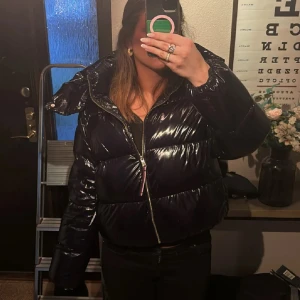 Marinblå pufferjacka från Tommy Hilfiger - En glansig marinblå pufferjacka från Tommy Hilfiger med oversized passform. Den är i storlek L men passar mig som brukar ha s/m. Denhär jackan är sååå snygg men tyvärr har jag tröttnat på den då jag köpte den 2022 för 5000kr. Jackan är i super bra skick, har använd massor men den är typ som ny, inga defekter. Alltså super bra kvalitet!!! 