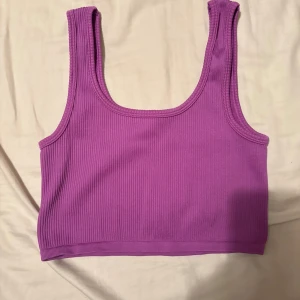 Lila ribbad linnetopp från FB Sister - Säljer en lila ribbad linnetopp från FB Sister i storlek S. Toppen är croppad med breda axelband och har en tight passform. Perfekt att styla med höga jeans eller kjol för en trendig look. Aldrig använt linnet så det är i fint skick. Fler bilder kan skickas om önskas och pris går att diskutera