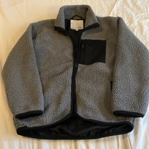 Teddy jacka - Fin grå teddy jacka som passar både flicka och pojke.Fint använt skick.Dragkedja fram.Från Lager 157.Tror nypris var 150kr.Passa på frifrakt på denna nu i 7 dagar.