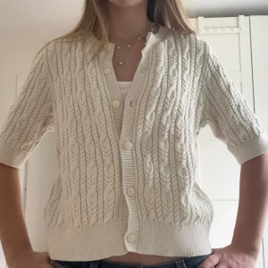 Stickad Kortärmad Kofta - Beige stickad kortärmad kofta från Holly & Whyte, köpt på Lindex!💖Storlek M men passar även S!