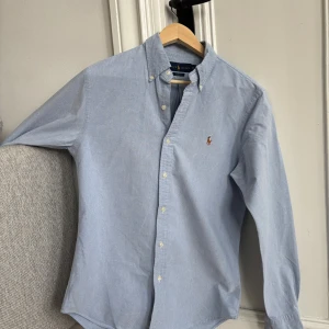 Blå|Ralph Lauren|Skjorta|Slim Fit|Storlek M - Fin Blå Ralph Lauren skjorta storlek M slim fit. Riktigt fint skick inga defekter. Hör av er vid funderingar! Kika gärna in mina andra skjortor för bundle rabatt!😊