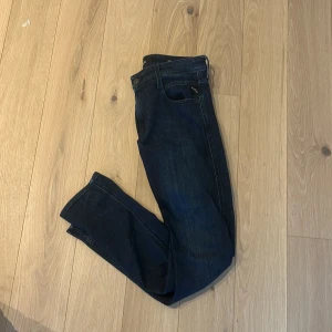 Mörkblå Replay jeans anbass - Säljer ett par mörkblå jeans från Replay med klassisk femficksdesign och raka ben. Jeansen har snygga kontrastsömmar och diskret Replay-logga på bakfickan. Perfekta för dig som gillar en tidlös och clean look. Strl: W30 L32. Hör av er vid intresse av flera bilder! 