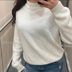 Vit stickad polo tröja  - Säljer en vit stickad tröja med high neck/polotröja  och långa ärmar. Tröjan har en ribbad struktur och en relaxed passform som är både snygg och enkel att styla till jeans eller kjol. Perfekt för kyligare dagar!