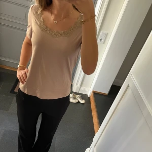 Beige topp med spets - Beige/brun tröja med spets från Anne Weyburn i storlek 38, passar S och M. Fint skick. Använd gärna köp nu!