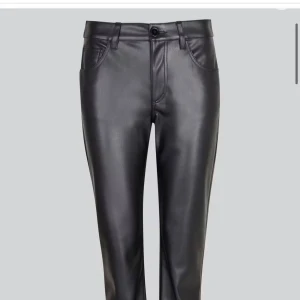 Svarta skinnbyxor med raka ben - Snygga svarta byxor i skinnimitation med klassisk femficksdesign och raka ben. Byxorna har bälteshällor, knapp och dragkedja framtill samt bakfickor. Perfekta för dig som vill ha en edgy och stilren look.