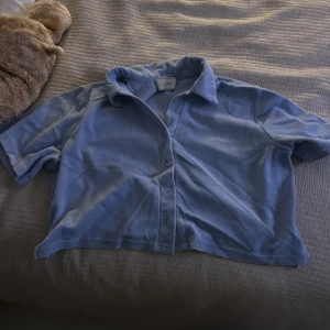 Ljusblå frottéskjorta med kort ärm - Säljer en ljusblå skjorta från neo noir i mjuk frotté. 