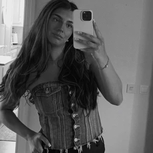 Jeanskorsett från Zara med knappar - Säljer en snygg jeanskorsett från Zara i storlek L. Toppen är axelbandslös med silverfärgade knappar framtill, två fejkfickor med knappdetaljer. 