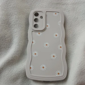 Blommigt mobilskal för Samsung Galaxy - Snyggt och tåligt mobilskal med prästkrage-motiv, designat för Samsung Galaxy-modeller med trippelkamera. Skalet är i mycket gott skick, flexibelt och ger bra skydd. Perfekt för dig som vill kombinera stil och funktion. Inga synliga defekter eller slitage.