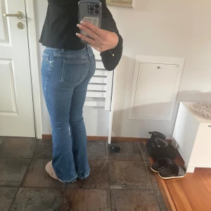 Blå mid- low flare jeans med bootcut - Snygga blå jeans från Gina Tricot med låg midja och bootcut/flare passform. Klassisk femficksmodell, stretchigt denimtyg och normalblå tvätt. Obs: byxorna är nedsträttna ☺️midja: S längd: 31