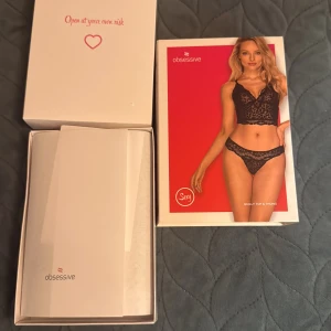 Svart leopardmönstrad spetskorsett Obsessive - Säljer en svart korsettopp från Obsessive med leopardmönster och spetsdetaljer. Toppen har v-ringning, smala axelband som korsas i ryggen och en liten dekorativ knapp framtill. Materialet är mjukt och stretchigt med transparent spets.