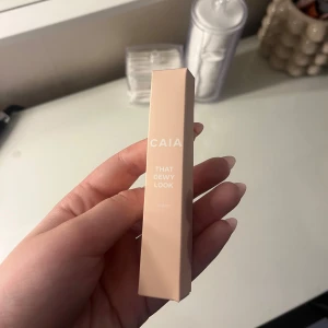 CAIA That Dewy Look Eye Gloss - Säljer en CAIA That Dewy Look Eye Gloss i snygg beige förpackning. Denna ögonglans ger en glansig, dewy finish till ögonlocken och innehåller återfuktande hyaluronsyra. Formulan är krämig och klibbfri för en fräsch look.