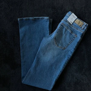 Jeans bootcut - Snygga blå Levi's 517 jeans med klassisk bootcut-passform. Jeansen har fem fickor, normal midja och är tillverkade i slitstarkt denim. Perfekta för dig som gillar en tidlös look med lite vidare ben. Märkespatch bak i midjan.